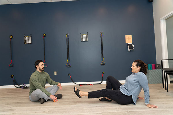 doctor coaching a woman through corrective exercises at In8 Wellness in North Andover